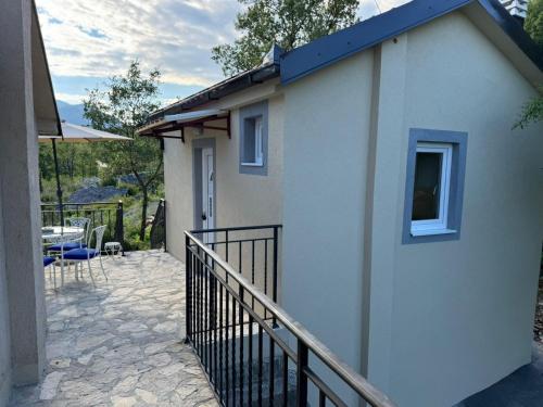 a small house with a balcony and a patio at Villagio in Virpazar