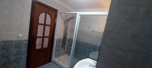 a bathroom with a toilet and a glass shower at Appartement Marina Beach, Mdiq in M'diq