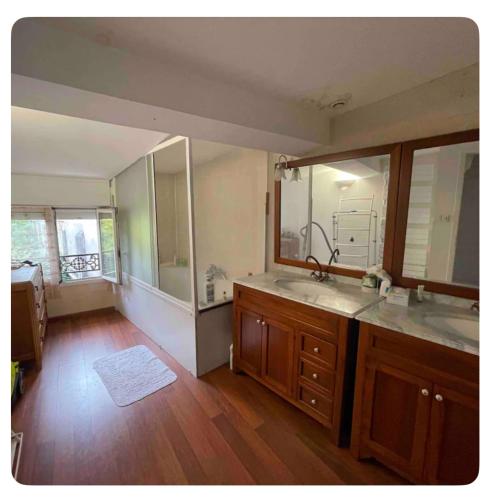 une salle de bain avec deux lavabos et un grand miroir dans l'établissement Chambre privée Yoko, à Talence