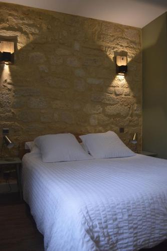 - une chambre avec un lit et deux lumières sur le mur dans l'établissement Maison Lambert, à Domme