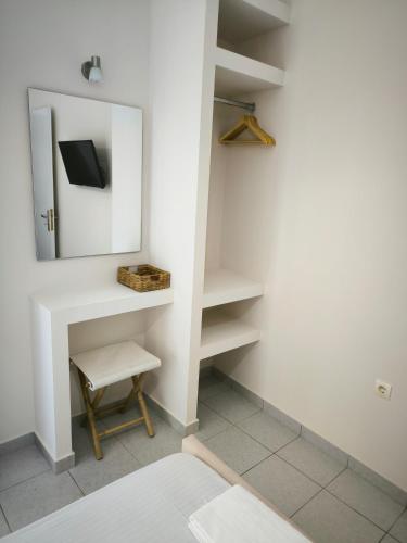 a dressing room with a mirror and a stool at Aggelika Apartments in Lithakia