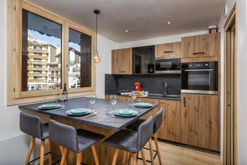 une cuisine avec une grande table et des chaises en bois dans l'établissement Chamonix Sud - Triolet A109 - Happy Rentals, à Chamonix-Mont-Blanc