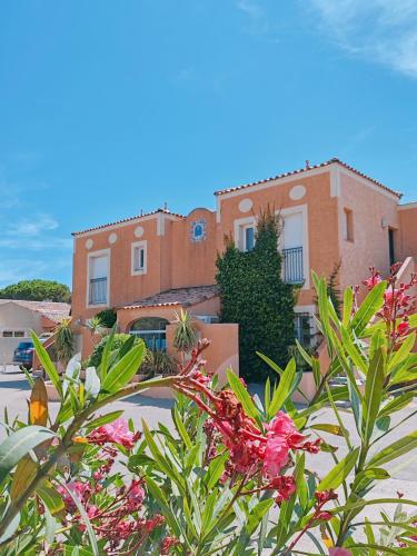 a building with a bunch of flowers in front of it at Résidence l'Oustal des Mers in Gruissan
