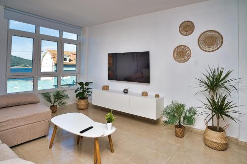 a living room with a couch and a tv on a wall at Apartamento SOLPOR in Finisterre