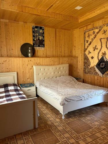 ƏrǝkitにあるKarvansaray Lahicの木製の壁の部屋にあるベッドのある寝室