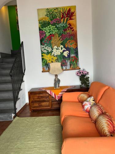 an orange couch in a living room with a painting at Casa Calandra in Canneto
