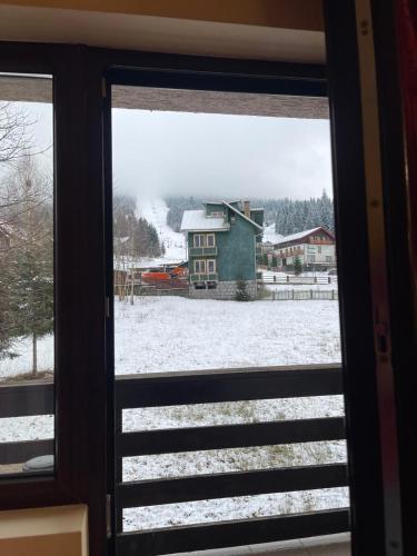 a view of a snow covered yard from a window at Hotel River in Borşa