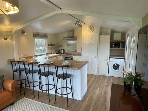 a kitchen with a island with bar stools at Stunning farm retreat in Tyes Cross