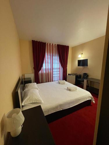 a hotel room with a bed and a window at Hotel River in Borşa