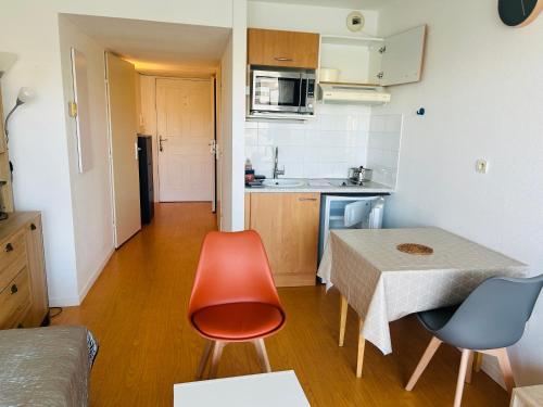 une petite cuisine avec une table et des chaises dans une pièce dans l'établissement L'Horizon - Parking - Piscine, à La Rochelle