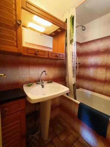 a bathroom with a sink and a bath tub at Maison à 150 m Plage 6LT221 in Saint Pierre La Mer
