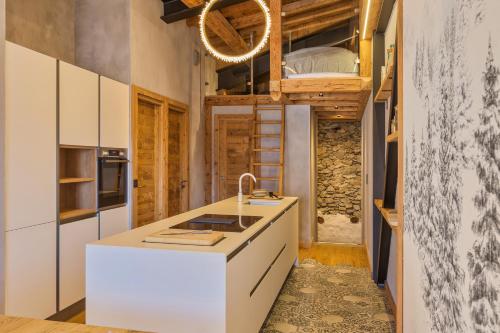 a kitchen with white cabinets and a sink in a room at La Ferme à Roland ski in - ski out - Happy Rentals in Chamonix-Mont-Blanc