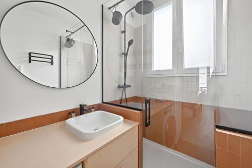 une salle de bain avec un lavabo et un miroir dans l'établissement Veeve - Charismatic Living, à Paris