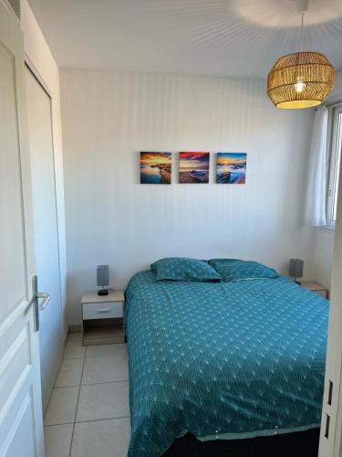 une chambre avec un lit et deux tableaux au mur dans l'établissement Appartement lumineux climatisé avec terrasse, à La Ciotat