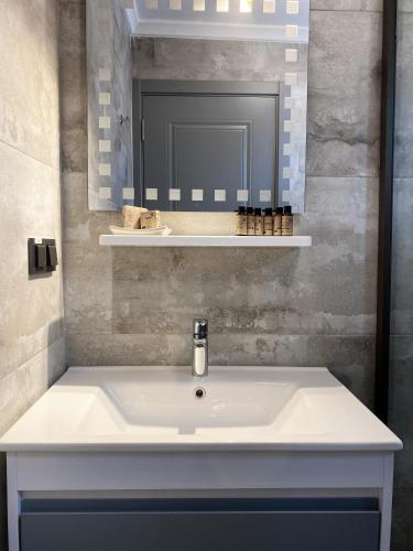 a bathroom with a white sink and a mirror at L'ETRO MAISON ALACATI HOTEL in Çeşme