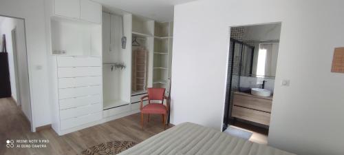 - une chambre avec une chaise rouge et un miroir dans l'établissement Belle maison neuve proche La Rochelle, à Ferrières