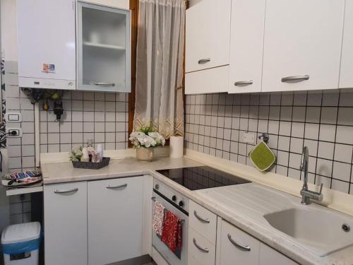 une cuisine avec des armoires blanches et un évier dans l'établissement Fabiana, à Bologne