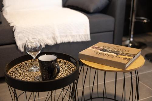 a book on a table next to a glass of wine at Plane Tree House in Kardhakáta
