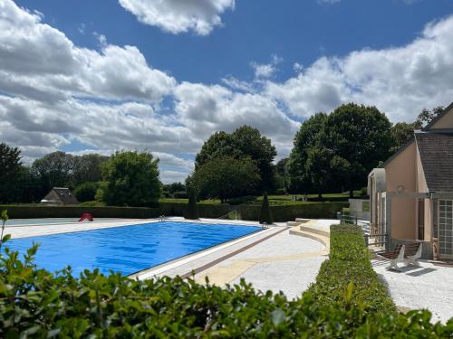 una piscina in un cortile accanto a una casa di Le Haut-Val Résidences a Bellême
