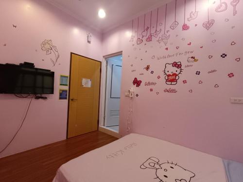 a bedroom with hello kitty stickers on the wall at Xiaoliuqiu Guest House in Xiaoliuqiu