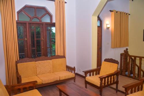 a living room with two chairs and a window at Elisach Serenity House - 4 BHK Villa in Sri Lanka - near to Airport in Negombo