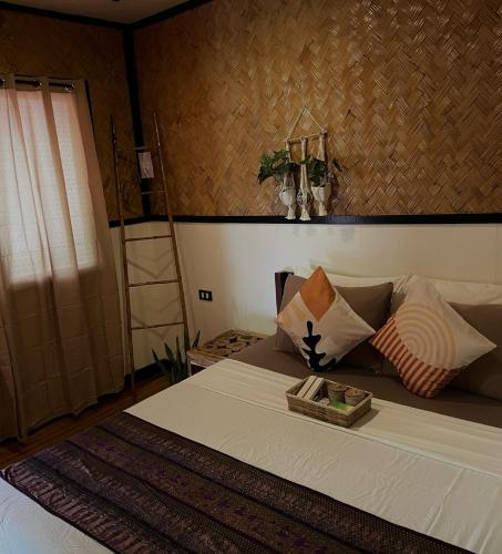 a bedroom with a bed with a tray on it at Hidden of Cailan Extension Transient House in El Nido