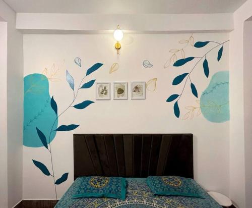 バラナシにあるEgarden Bhakti Yog 2 BHK Suite with Balconyのベッドルーム1室(青い葉の壁にベッド1台付)