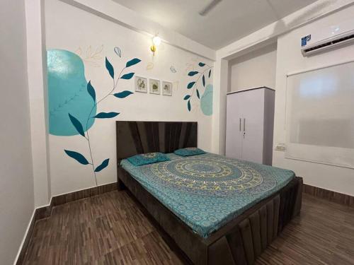 バラナシにあるEgarden Bhakti Yog 2 BHK Suite with Balconyの壁に壁画が施されたベッド付きのベッドルーム1室