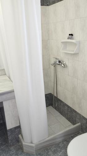 a shower with a shower head in a bathroom at Olympos Studios in Amoopi