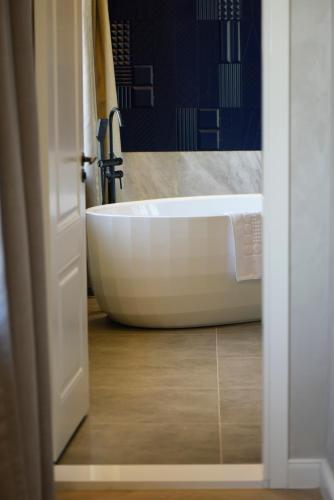 a white bath tub in a bathroom with a mirror at Ulaanbaatar Hotel in Ulaanbaatar