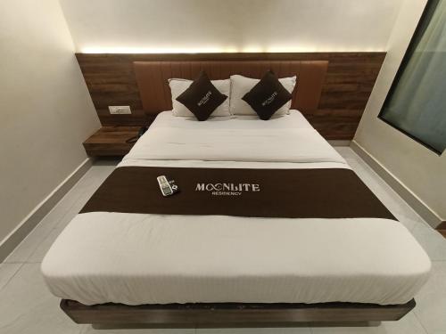 a bed in a room with a large white bed at HOTEL MOON LITE RESIDENCY - Marve Road Malad West in Mumbai