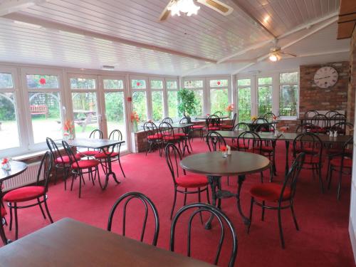 a dining room with tables and chairs and a clock at Ganton Greyhound Inn in Ganton