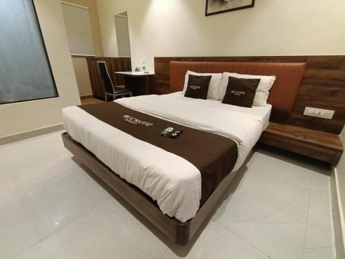 a bedroom with a large bed with a wooden headboard at HOTEL MOON LITE RESIDENCY - Marve Road Malad West in Mumbai