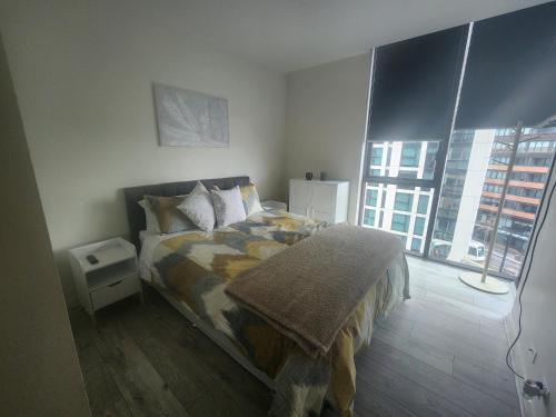 a bedroom with a bed and a large window at One bedroom apartment in Docklands in Melbourne