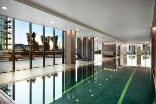 a large building with a swimming pool in a building at One bedroom apartment in Docklands in Melbourne