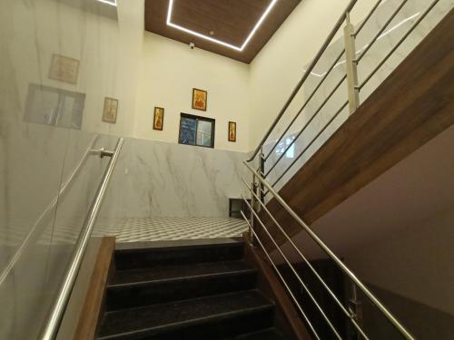 a staircase in a building with a metal railing at HOTEL MOON LITE RESIDENCY - Marve Road Malad West in Mumbai