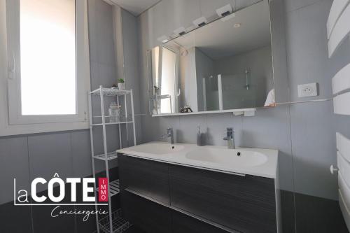 une salle de bain avec un lavabo et un miroir dans l'établissement Appart Juliette, à Carry-le-Rouet