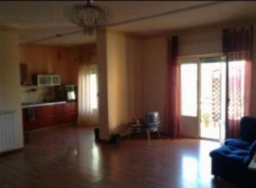 Una sala de estar con un sofá azul y una cocina. en Locazione turistica, en Rossano Stazione