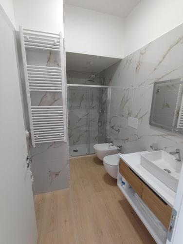 a bathroom with a sink and a toilet and a mirror at Morfeo appartamenti e camere in Palmi