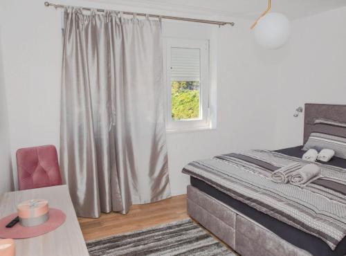 a bedroom with a bed and a table and a window at Apartment Matko in Ploče