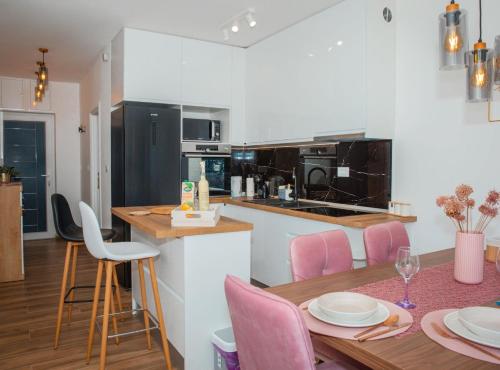 a kitchen and dining room with a table and pink chairs at Apartment Matko in Ploče