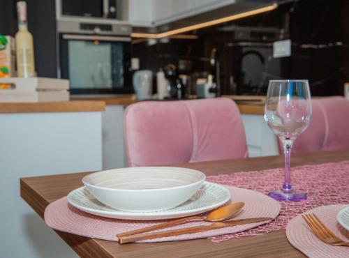 a table with a bowl and a glass of wine at Apartment Matko in Ploče