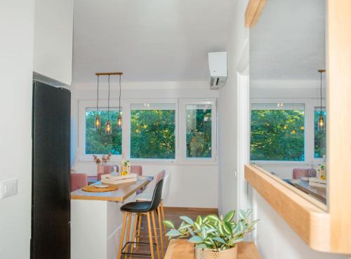 a kitchen with a table and chairs and windows at Apartment Matko in Ploče
