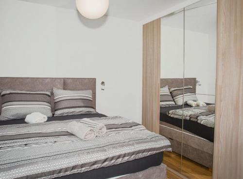 a bedroom with a bed and a mirror at Apartment Matko in Ploče
