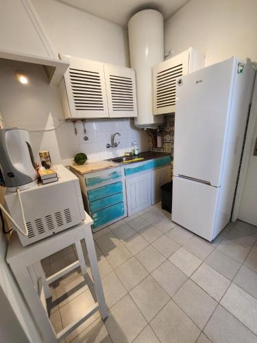 a kitchen with a white refrigerator and blue cabinets at Blife Faro Beach Hostel & Rooms in Faro