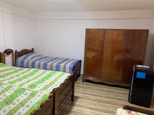 a bedroom with two beds and a wooden cabinet at Marina kvariati in Kvariati