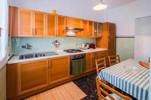 a kitchen with wooden cabinets and a table and a table and a dining room at Sestri Levante Acquamarina in Sestri Levante
