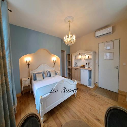 - une chambre avec un lit blanc et un lustre dans l'établissement La Maison du Canal - Homps - Le Sweet, à Homps