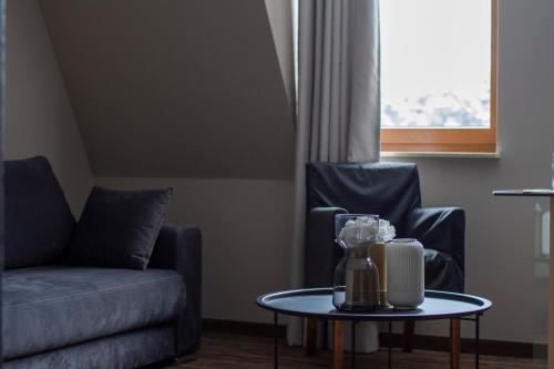 a living room with a couch and a table at Hotel Natura Residence Business&SPA in Siewierz