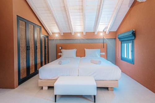 a bedroom with a large bed and a large window at Tessera Villas & Studios Collection in Gouvia